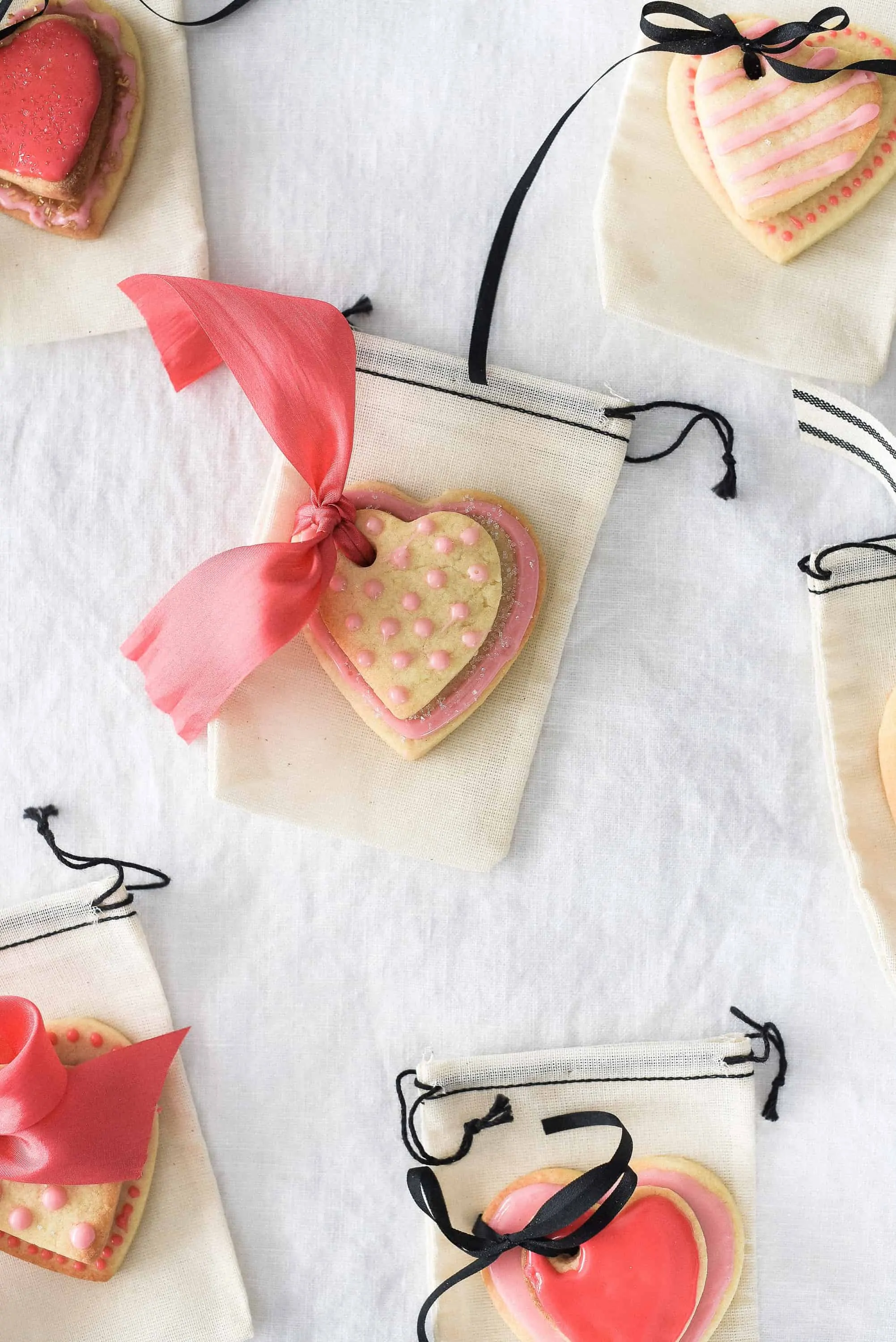 These Valentine’s Day sugar cookies are topped with simple royal icing and sprinkles and couldn’t be cuter! Use a little ribbon to turn these Valentine’s Day sugar cookies into the sweetest Valentine treat!