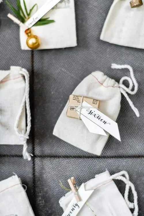 This DIY Christmas advent calendar is made using antique French grain sifters and muslin bags, plus click below to download each day’s printable for free!