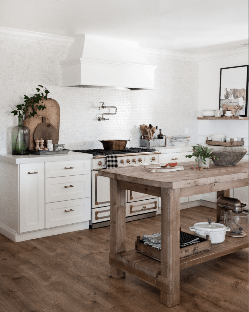 Farmhouse kitchen with french range, white shaker cabinets, wood island, and Pergo wood flooring in Riverbend Oak.